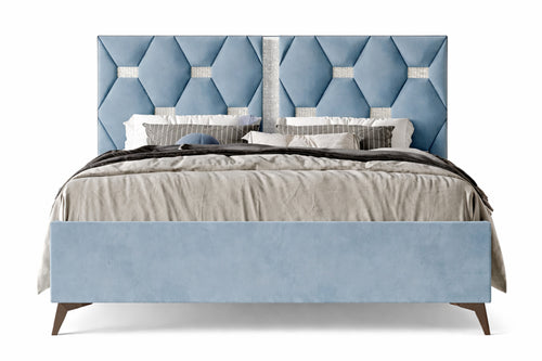 Cama tapizada en azul con cabecero estampado en forma de rombos sobre fondo blanco.
