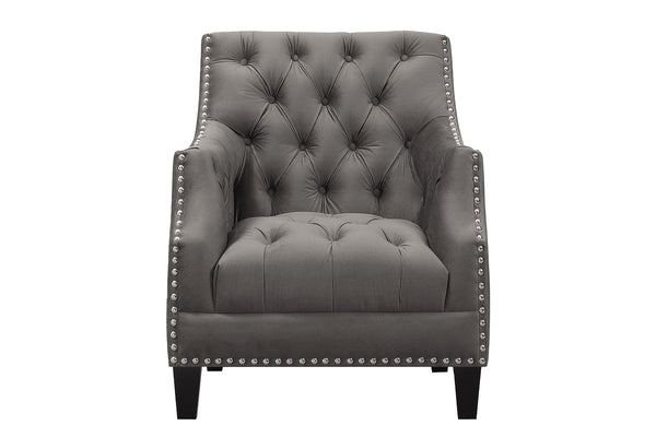 Sillón gris con respaldo capitoné y detalles de tachuelas sobre fondo blanco.