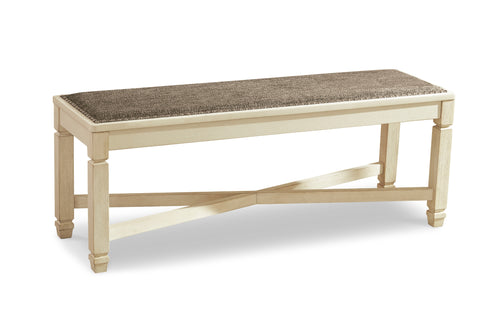 Un banco de madera natural clara con asiento tapizado en color topo texturizado, mostrado desde un ángulo de tres cuartos sobre un fondo blanco.