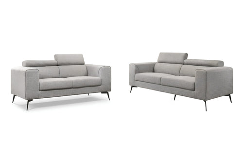 Un sofá de dos plazas tapizado en gris claro y un sillón a juego, mostrados uno al lado del otro sobre un fondo blanco y limpio.
