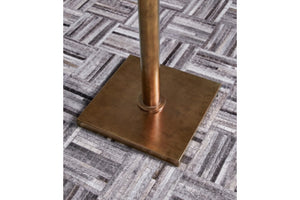 Base de lámpara de bronce sobre alfombra estampada.