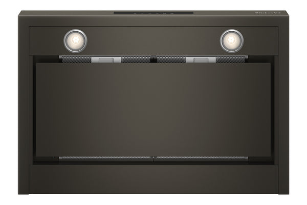 Vista inferior de campana extractora KitchenAid en acabado negro con dos luces LED encendidas, filtros metálicos de grasa visibles y panel frontal abatible, presentada sobre fondo blanco.
