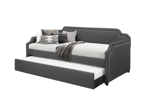 Cama tapizada con trundle de color gris sobre un fondo blanco. 