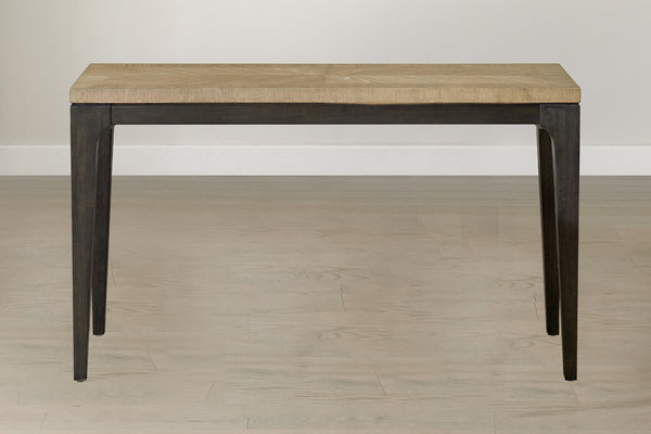 Vista frontal de mesa rectangular de consola con tope de madera marrón con base negra en un ambiente de sala neutral. 