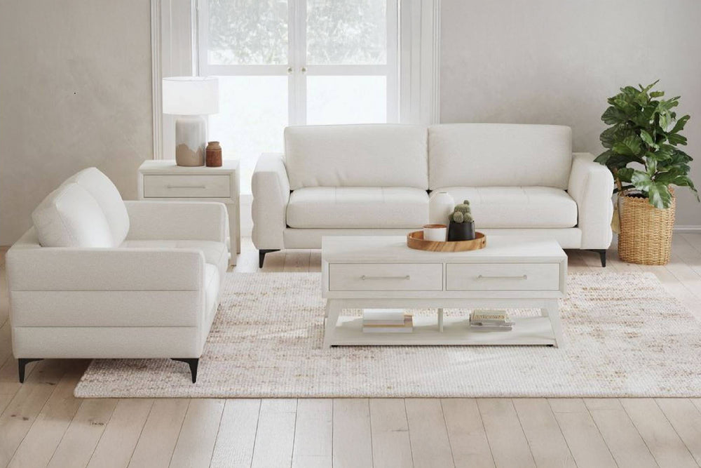 Sofá y loveseat blancos con patas metálicas negras en un entorno de sala moderna con mesa de centro. 