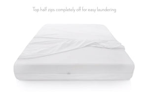 Sábana ajustable blanca con la mitad superior desmontable con cremallera sobre un fondo blanco