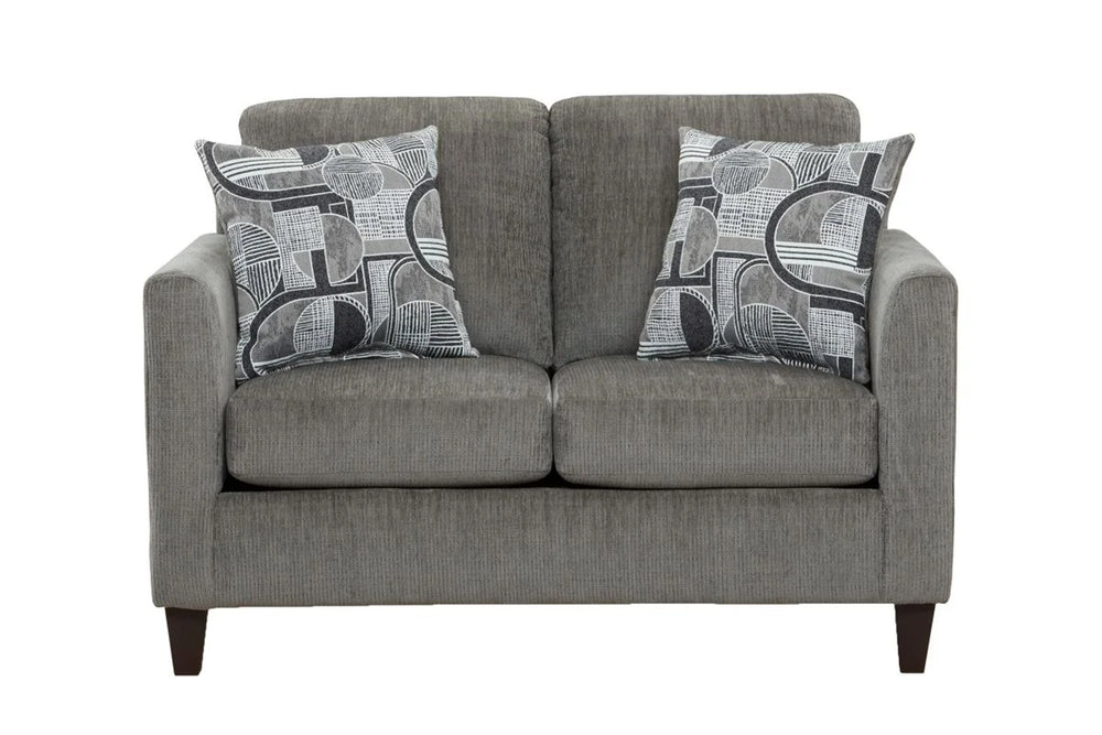 Loveseat moderno tapizado en tela gris con cojines de asiento amplios, apoyabrazos rectos y dos cojines decorativos con diseño geométrico en tonos gris y blanco, presentado sobre fondo blanco.