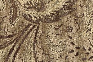 Primer plano de una tela texturizada marrón y beige con intrincados diseños.