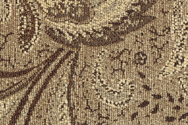 Primer plano de una tela texturizada marrón y beige con intrincados diseños.