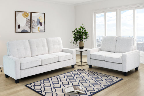 Sofá y loveseat de color blanco con elementos decorativos en una sala iluminada. 