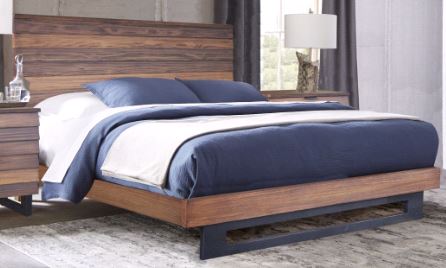 Cama de madera con ropa de cama azul y blanca en un habitación.