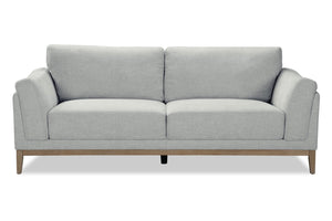 Sofá gris con patas de madera sobre fondo blanco.