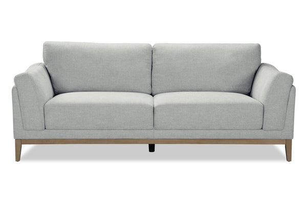 Sofá gris con patas de madera sobre fondo blanco.