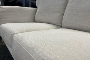 Sofá de tela beige con superficie texturizada.