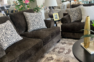 Sofá y loveseat modular marrón con cojines estampados en una sala de exposición.