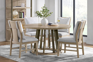 Comedor con una mesa redonda de madera y cuatro sillas a juego con cojines grises.